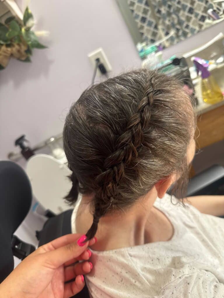 AmanaCare’s caregiver Abigail braiding a client's hair.